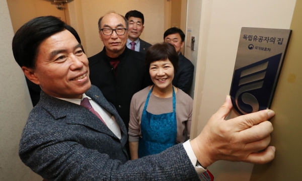 황인호 동구청장이 이진섭 애국지사의 아들 이완순 씨의 자택을 방문해 명패를 달고 있다