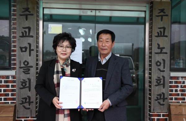 홍성 주교마을 용대기 기탁_역사문화시설관리사업소 강애란 소장(왼쪽)이 주교마을 이환중 이장(오른쪽)에게 기탁증서를 전해주고 있다