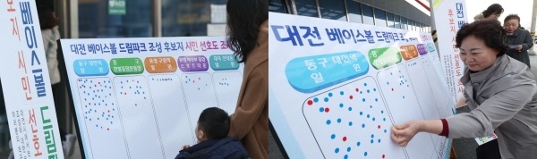 시민들이 선호도 조사 판넬에 스티커를 붙이고 있다.