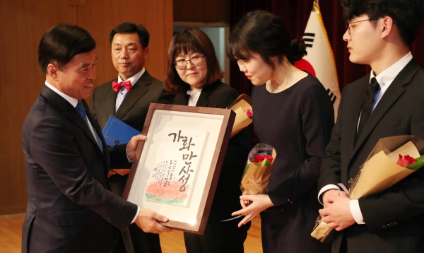 황인호 청장이 일곱빛깔 무지개 가족에게 ‘가화만사성’ 액자를 선물하고 있다
