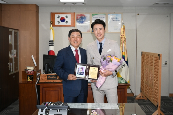 황선봉 군수가 가수 신성 씨에게 공로패를 전달하고 있다.