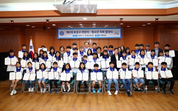 제2대 유성구 어린이·청소년 의회 발대식’에서 정용래 유성구청장(맨 뒷줄 가운데)과 하경옥 유성구의회 의장(셋째줄 왼쪽에서 세 번째)을 비롯한 의원들이 어린이·청소년 의원들과 기념촬영