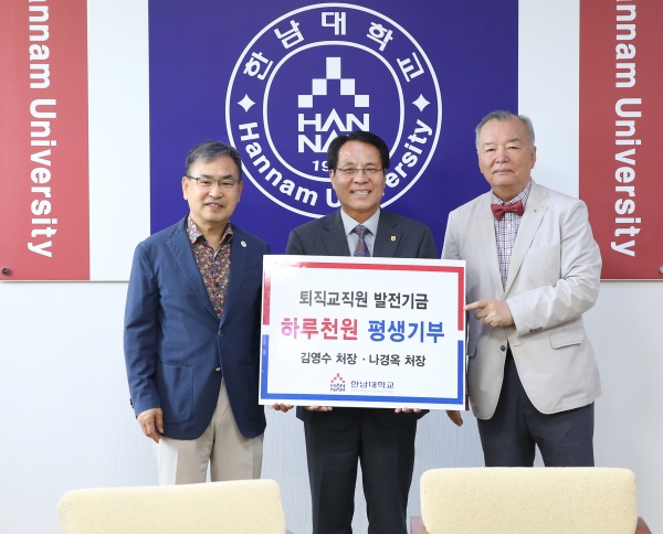 한남대 퇴직직원인 김영수 씨(사진 오른쪽)와 나경옥 씨(사진 왼쪽)가 이덕훈 총장에게 발전기금을 기탁하고 있다.