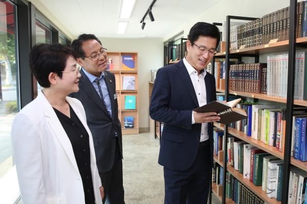 자치구 정책투어의 하나로 한남대 ‘창업존’을 찾은 허태정 대전시장(오른쪽)이 박정현 대덕구청장(왼쪽), 한남대 이덕훈 총장(중앙)과 중고서점에서 책을 살펴보고 있다.