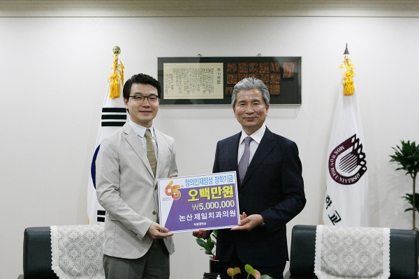 논산 제일치과의원 오진섭 원장(왼쪽)이 목원대 권혁대 총장(오른쪽)에게 장학기금 500만 원을 전달하고 기념촬영 하고 있다.