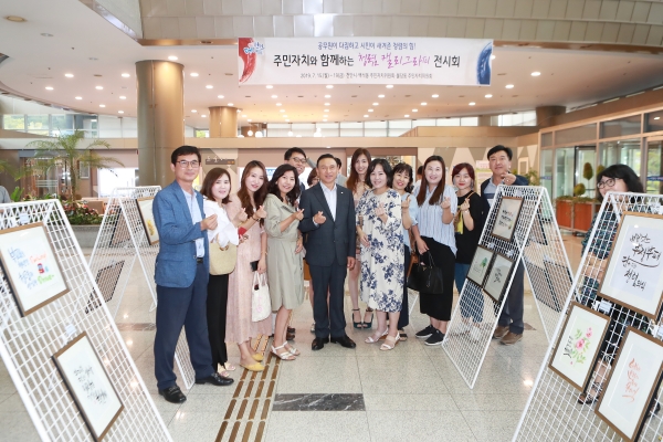 구본영 천안시장이 15일 청렴 캘리그라피 전시회를 둘러보며 직접 작품을 만든 백석동, 불당동 주민자치위원회와 기념사진을 찍고 있다.