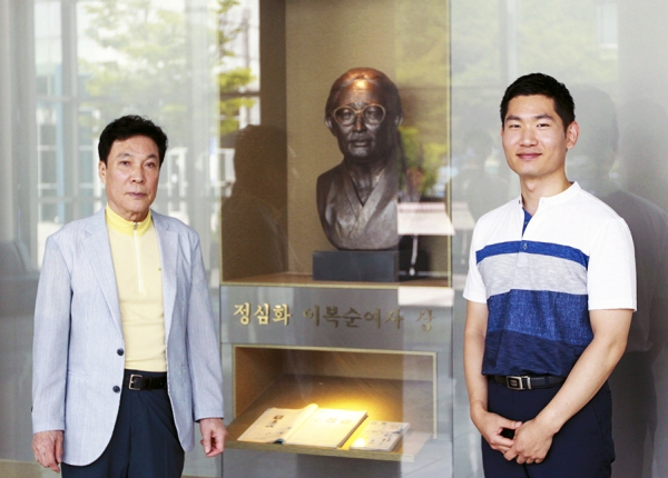 김밥할머니 덕분에 미국 대학 교수된 박준표 동문(유가족 임채훈 씨와 박준표 동문이 정심화국제문화회관 내에 마련된 정심화 이복순 여사 상 앞에서 기념 사진을 찍었다)