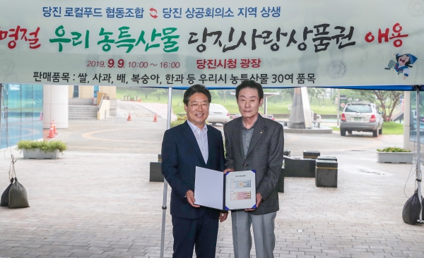 추석맞이 직거래장터 사진 (당진상공회의소 당진사랑상품권 구매 기념 사진_왼쪽 김홍장 시장 오른쪽 이범주 상공회의소 회장).