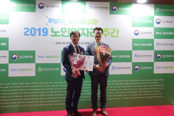 한국서부발전 이상현 국정과제추진실장(좌)이 『2018년 노인 일자리창출 분야 우수기업 보건복지부 장관상』을 수상한 뒤, 소삼영 사회공헌부장과 함께 기념촬영을 하고 있다.