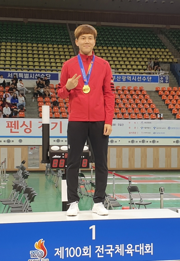 하태규선수가 시상대에서 금메달을 목에 걸고 있다.