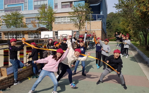 천안용소초등학교 5학년 4반 학생들과 (사)충남 어린이 안전학교 회원들이 교내 펜스에 직접 선정한 도안을 바탕으로 패브릭 그래피티 작업을 하고 있다.