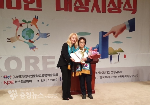 김미영 의원의 어머니가 대리 참석하여 수상하고 기념촬영을 하고 있다.