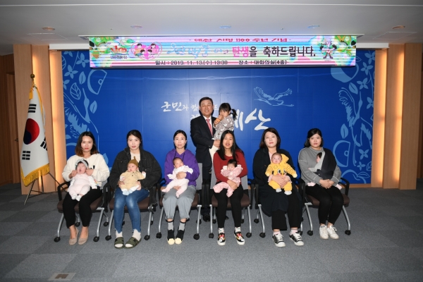 황선봉 예산군수(사진 가운데)와 신생아, 부모들이 천백둥이 액자 조형물 증정 후 기념촬영을 하는 모습