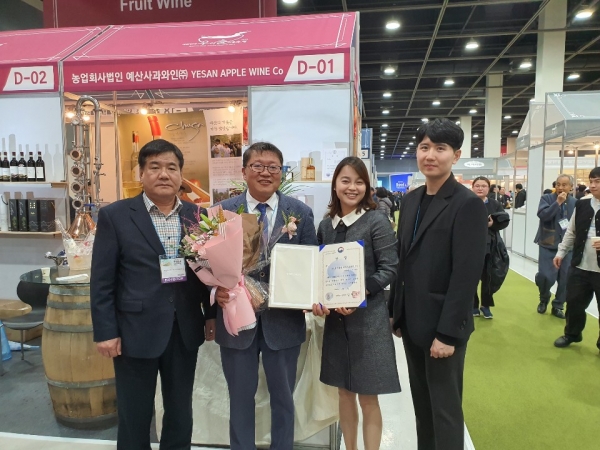 예산사과와인 정제민 부사장(왼쪽에서 두번째)과 군 관계자들이 수상 후 기념촬영을 하는 모습