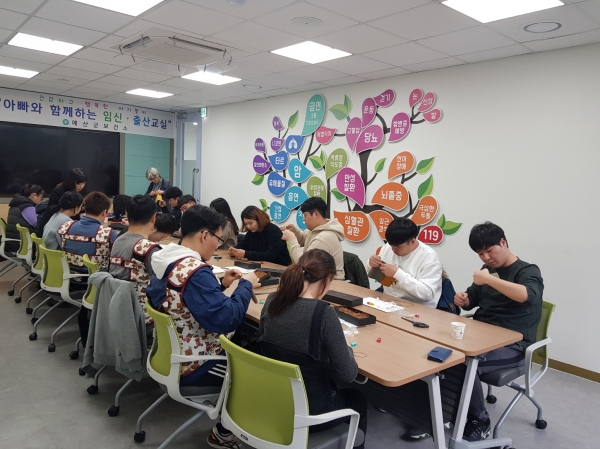 아빠와 함께하는 임신·출산교실 참가자들이 통장 만들기를 하는 모습