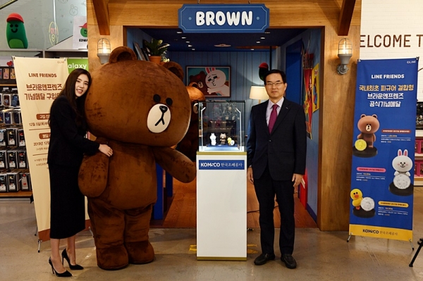 ​‘브라운앤프렌즈 기념메달’을 공개했다.조용만 사장(오른쪽)과 조폐공사 명예홍보대사인 연애인 손담비씨가 기념메달 앞에서 기념촬영하고 있다​