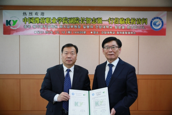 MOU체결후 협약서를 들고 기념촬영을 하고 있는 이원묵 총장(오른쪽)과 하지강 부원장(왼쪽)