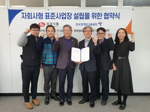 자회사형 장애인 표준사업장 설립 협약식에 참가한 ㈜성경식품과 한국장애인고용공단 관계자들이 파이팅을 외치고 있다.