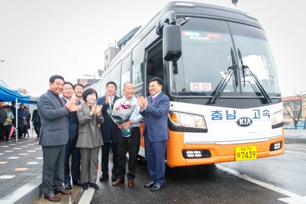 오세현 아산시장이 버스기사에게 개통 축하 꽃다발을 건넨 후 내빈과 함께 기념촬영하고 있다.