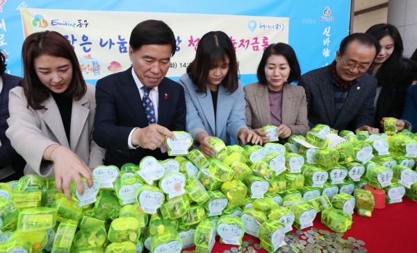 24일 구청 1층 로비에서 열린 천사 나눔저금통 기탁식에서 황인호 동구청장(사진 왼쪽에서 네 번째)과 이나영 동구의회 의장(사진 왼쪽에서 6번째)이 천사 나눔저금통을 개봉하고 있다