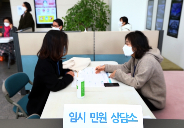 26일 유성구청 1층 로비에 준비된 임시 민원 상담소에서 담당공무원이 민원인에게 신청서 작성을 설명하고 있다.