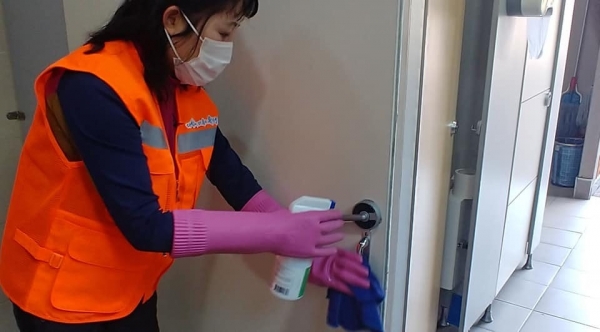 청소관리업체 직원이 유성의 한 공중화장실 손잡이를 소독하고 있다