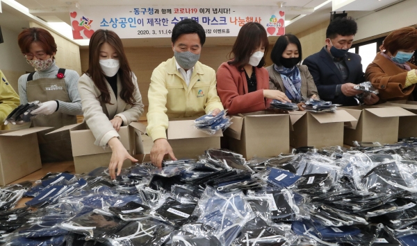 류은덕 마을살림공작소 대표(왼쪽 첫 번째), 황인호 동구청장(사진 가운데), 이나영 동구의회 의장(왼쪽 다섯번째), 박황순 중앙시장활성화구역상인회장(왼쪽 여섯 번째) 등 행사 참석자들이 수제 면 마스크를 상자에 담고 있다