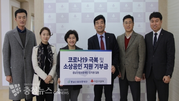 유성준 충남신용보증재단 이사장(오른쪽 3번째) 지난 12일 박은희 충남사회복지공동회 사무처장에게 코로나19 피해복구 및 지원을 위하여 재단 임원 및 직원이 자발적으로 모금한 성금을 전달하고 있다.