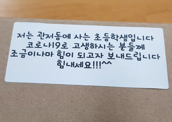 지난 9일 오전 10시경 서구 보건소 선별진료소로 초등학생이 배달한 편지가 붙은 떡 한 박스
