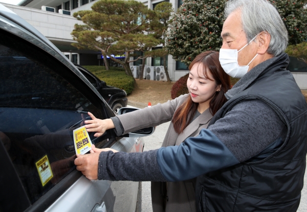 ‘고령운전자 표시 차량용 스티커’를 부착하는 모습.