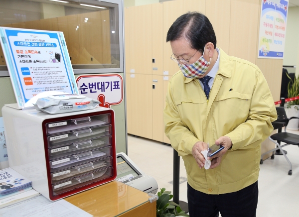 장종태 서구청장이 서구청 1층 세무1과 민원실에 코로나19 감염예방 및 지역확산 방지를 위해 비치한 항균 소독용 물티슈를 이용하여 핸드폰을 소독하고 있다
