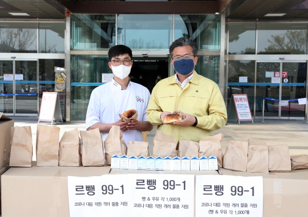 6일 구청 본관 입구에서 한도영 ‘르뺑 99-1’ 대표(왼쪽)가 정용래 유성구청장(오른쪽)에게 유성구청 직원을 위한 간식을 전달하고 있다