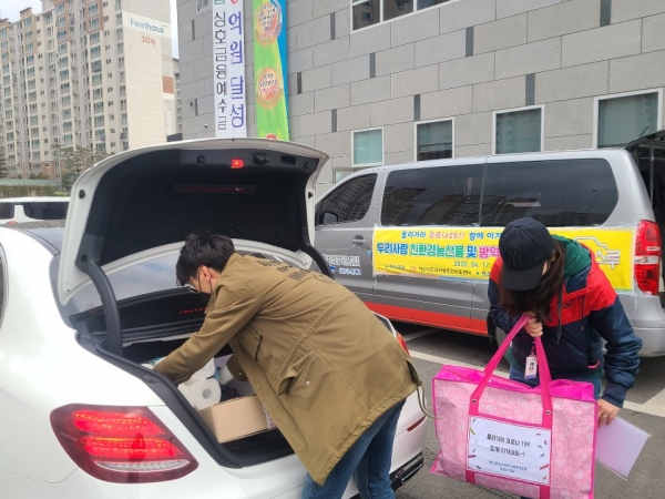 친환경농산물 및 방역꾸러미를 이용인 보호자 차량에 전달 중