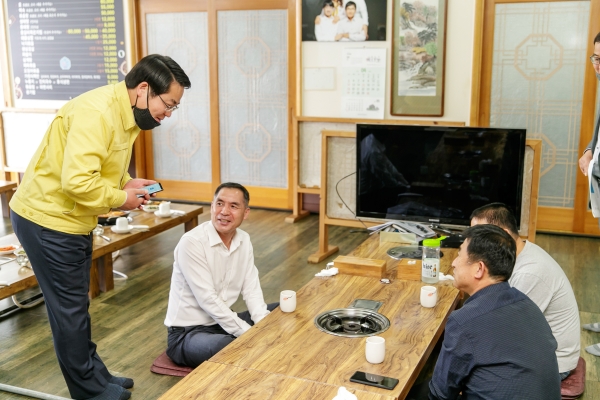 오세현 아산시장이 식당을 방문한 아산시민에게 모바일 아산사랑상품권을 홍보하고 있다.