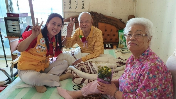 대한적십자사 아산지구협의회 봉사자가 어르신들께 꽃화분을 전달하고 있다.