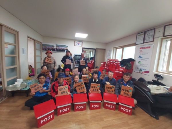 지곡면 산성1리 주민들이 마을회관에서 마을만들기 소액사업으로 추진한 우편함과 문패를 들어보이고 있다