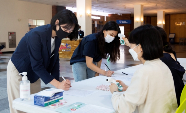 제한적 대면수업을 위해 배재21세기관에 출입하는 학생들이 발열 체크를 하고 있다.