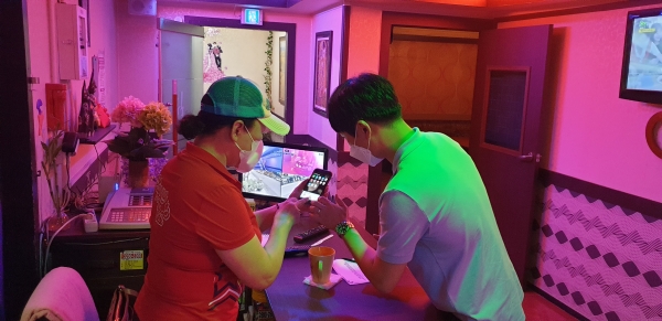 지난달 30일 유성의 한 단란주점에서 담당공무원이 영업주에게 전자출입명부 설치를 안내하고 있다