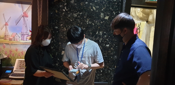 지난달 30일 유성의 한 단란주점에서 담당공무원이 영업주에게 전자출입명부 설치를 안내하고 있다