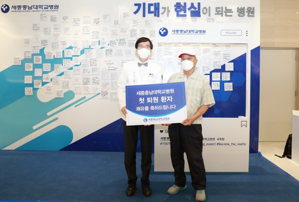 첫 퇴원 환자 쾌유 기원 건강검진권 제공/ 왼쪽 나용길 세종충남대병원장, 오른쪽 오분표 씨 남편