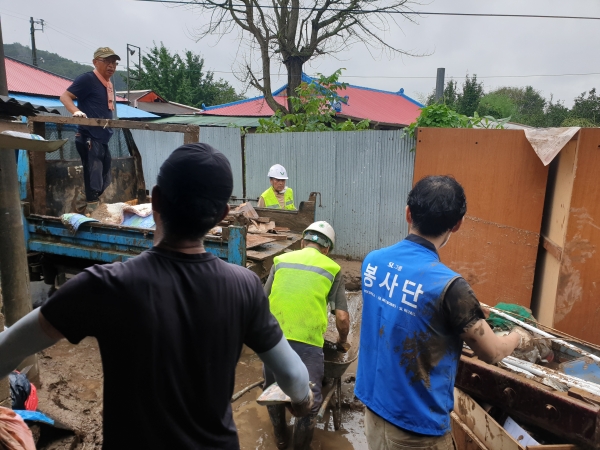 에스엘홀딩스 구성원들이 지난 6일 집중호우로 침수피해를 입은 천안시 동남구 목천면 소사리 마을일원에서 침수피해 주택을 찾아 토사제거와 가구정리 등 복구지원을 하고 있다.