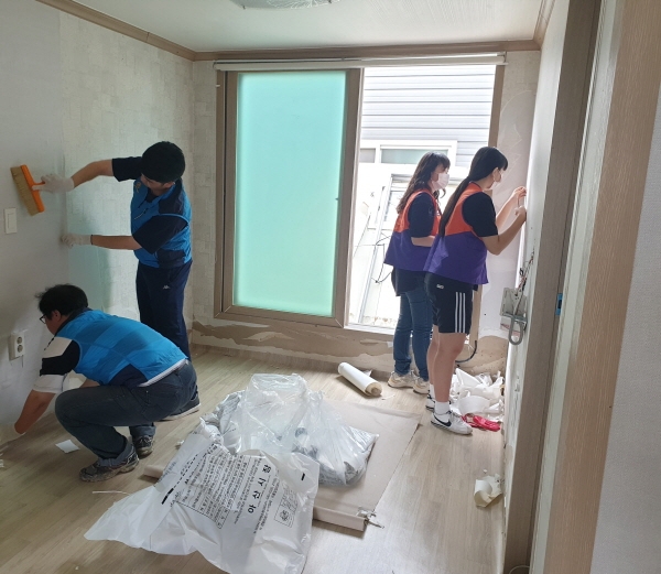 아산비젼과 온양중앙로타리 회원들이 지난 15일 온양3동 침수피해 가정에서 도배장판 시공을 하고 있다.