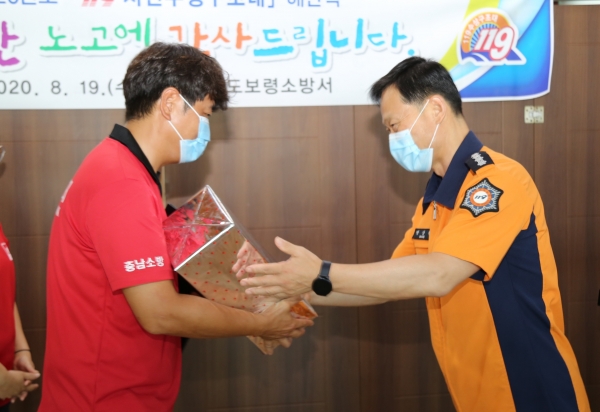 방상천(오른쪽) 보령소방서장이 119시민수상구조대원에게 감사의 뜻을 전하고 있다.