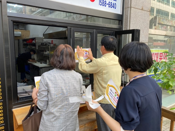 천안시와 위생단체가 합동으로 음식점 밀집지역에서 코로나19 예방을 위한 생활방역 수칙 현장 지도 및 스티커 부착 안내 등을 실시하고 있다.