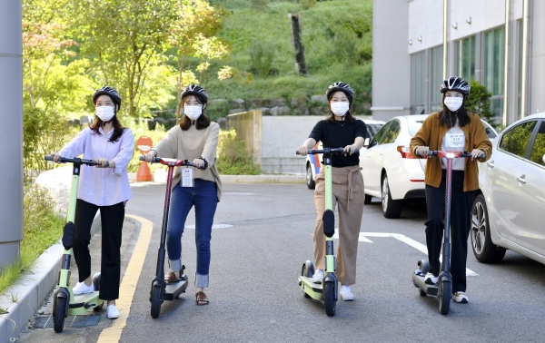 교수회로부터 받은 안전헬멧을 받은 학생들이 전동킥보드를 이용하고 있다