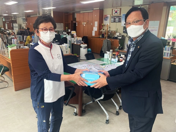 한 주민에게 마스크를 전달하는 최신호(오른쪽) 정산면 역촌2리장.