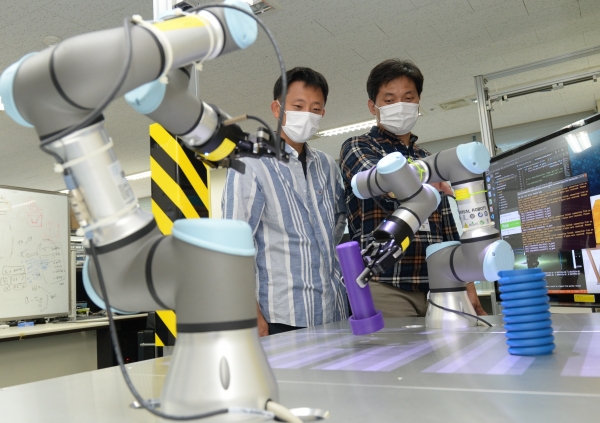 ETRI 연구진이 개발한 스마트팩토리용 로봇 자율지능 기술을 점검하고 있다.