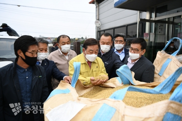 황선봉 예산군수가 2020년산 공공비축미곡 매입현장을 방문해 출하농가를 격려하며 벼 품위를 살펴보고있다