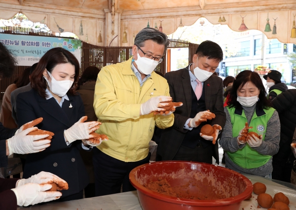 지난 4일 오후 온천로 일원 두드림공연장에서 정용래 유성구청장이 참여자들과 함께 하천수질 개선을 위해 사용될 EM황토흙공을 만들고 있다
