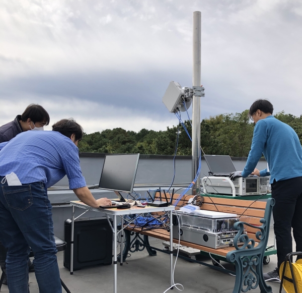 ETRI 연구진이 무선 백홀 기술을 실외에서 허브를 설치해 시험하고 있는 모습